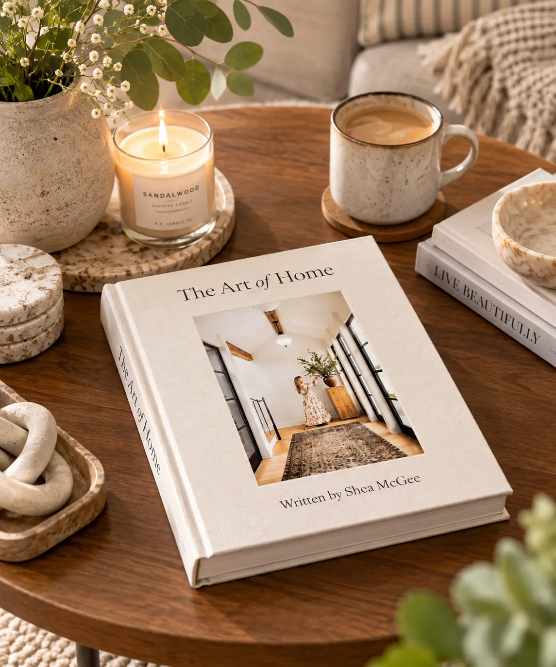 The Art of Home design book by Shea McGee styled on a wooden coffee table